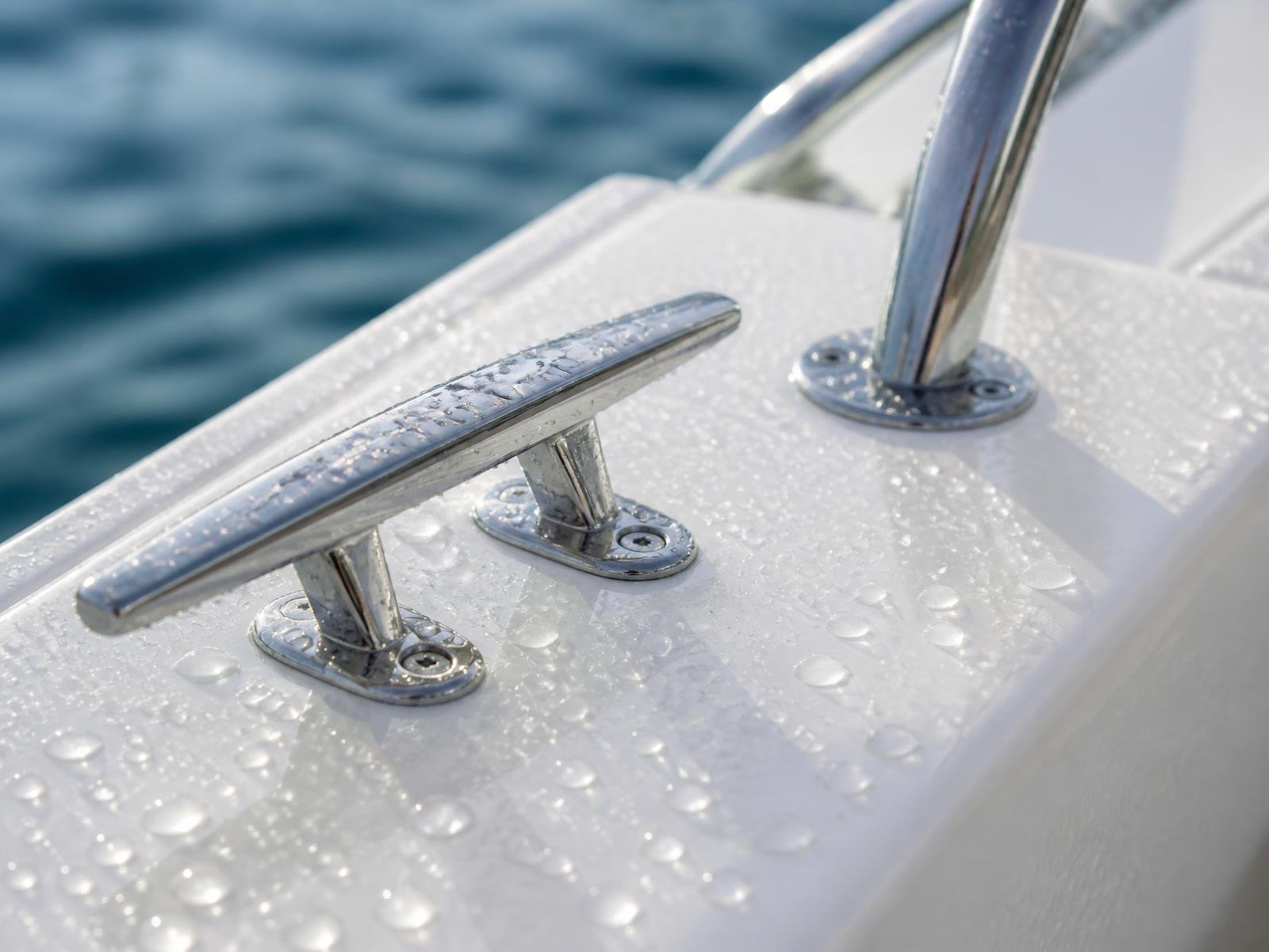 Illustrative close view of a glossy marine surface with water beading beside polished stainless hardware